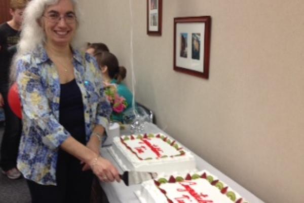 Dr. Tina Henkin cutting celebratory cake.