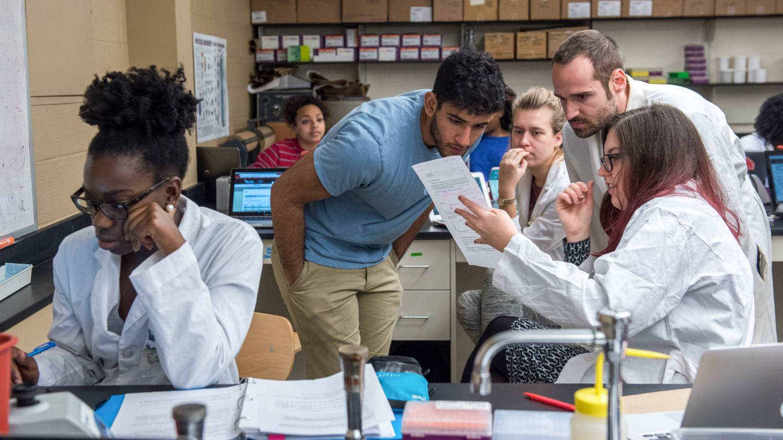 Students looking at a document in a laboratory